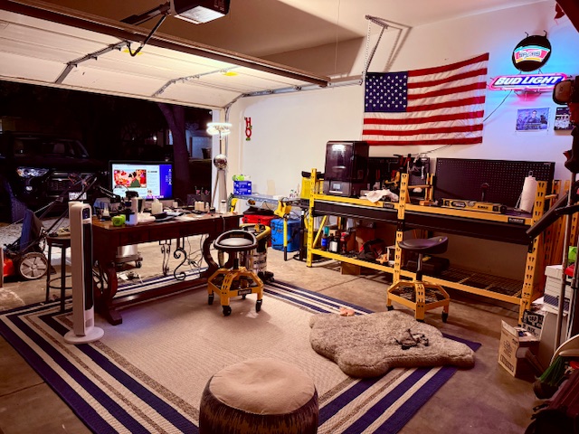 Dusty's Magic workshop garage with American flag, 3D printing station, and comfortable workspace
